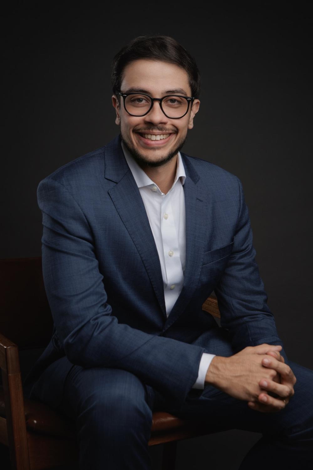 Dr. Douglas Dias, oncologista clínico, sentado e sorrindo